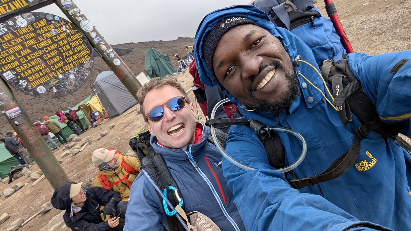 Sam and a guide at Lava Tower Camp on Kilimanjaro, 4,600 m, the camp and route sign behind them